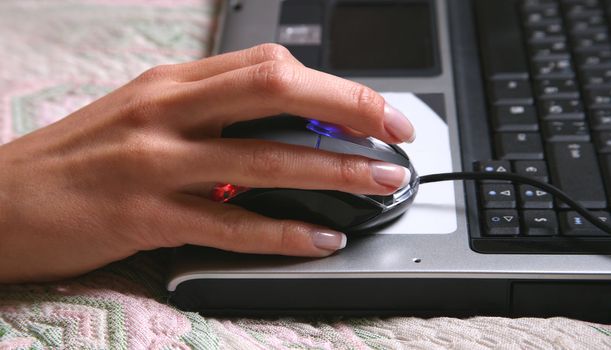 A woman's hand typing on a laptop