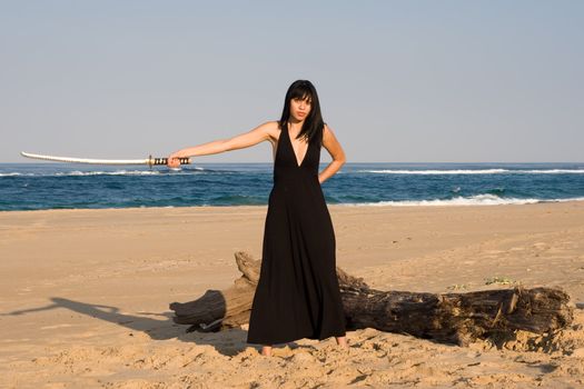 Asian model wielding a sword on the beach