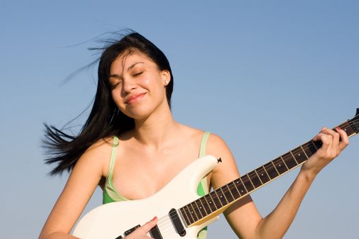 Girl in green dress playing a guitar