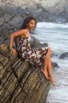 Caribbean model relaxing on the rocks at the beach