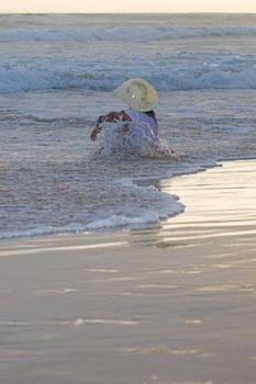 Girl in the water wearing a hat and t-shirt