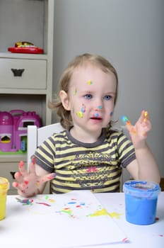 funny little girl and colored paints