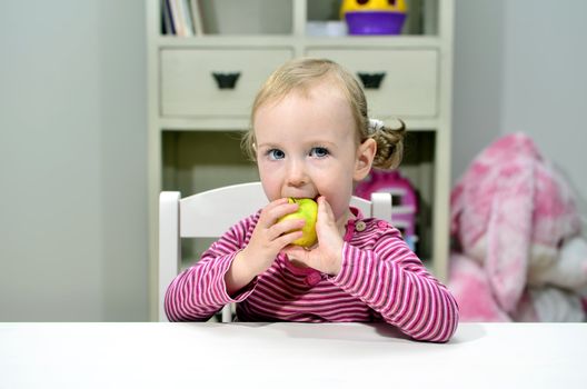 little girl eating green apple