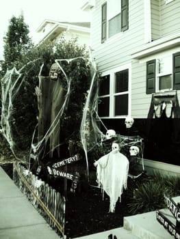 Spooky halloween decorations in front of a suburban home.