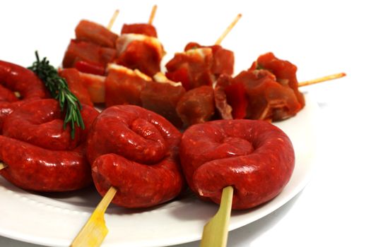 raw shashlik and sausages for barbecue on the white plate