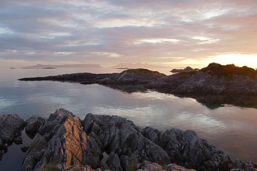 A view towards the islands of Eigg and Rum from Arisaig with a rocky foreground