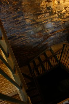 A dimly lit stairwell curls into the darkness.