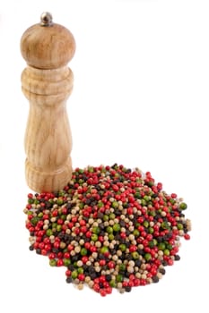 Pepper mill and colorful peppercorns on white background