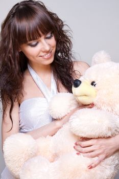 beautiful girl with a teddy bear on a gray background