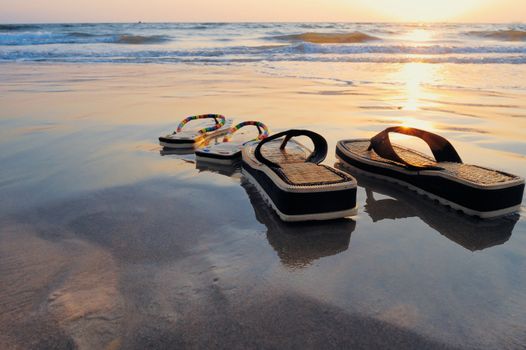 Beach sandals on the wet sandy shore