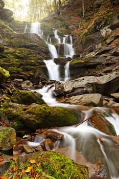 Photo of peaceful flowing mountain waterfall