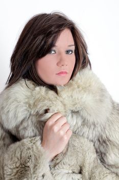 Portrait of a young brunette russian teenager girl with fur in studio