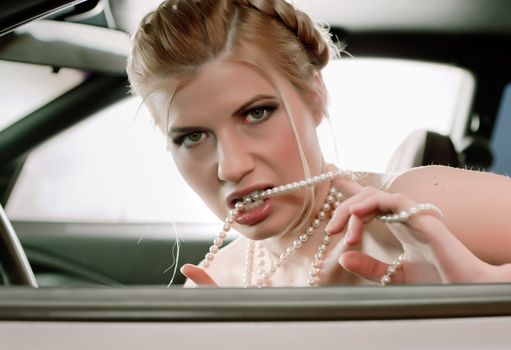   Young sexual blonde in the car. Pearl beads.