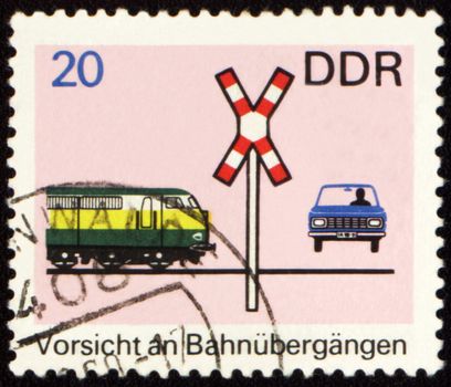 GDR - CIRCA 1960s: a stamp printed in GDR (East Germany) shows car on a railway crossing, devoted to the explaining rules of the road, circa 1960s
