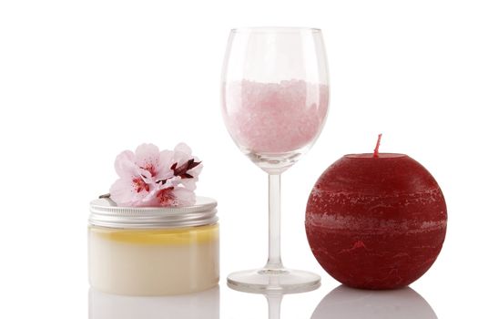Spa products, candle and cherry flower over white