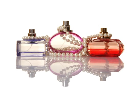 Perfume in a glass bottles and pearl beeds on white background