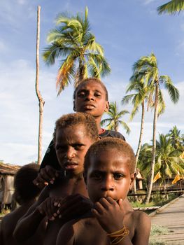 ASIA, INDONESIA, WEST PAPUA (IRIAN JAYA), ASMAT PROVINCE - 19 JANUARY:  Daut, Yali, Den - Children of uncertain age of a  asmat tribe  in a deaf forest small village see off a boat. 19 january 2009 