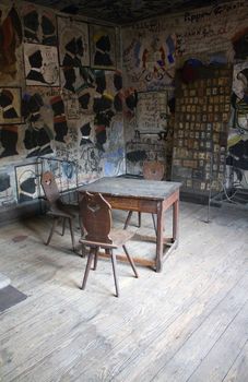A derelict and grafitied room lays still, illuminated by the setting sun.