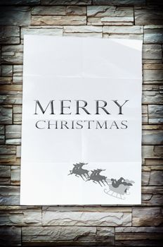 The merry christmas word on the crumpled paper with nice stone wall