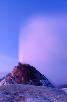 White Dome Geyser erupting after sunset, Yellowstone National Park, Wyoming, USA