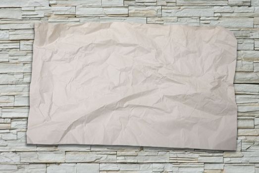 Old crumpled paper on stone wall background 