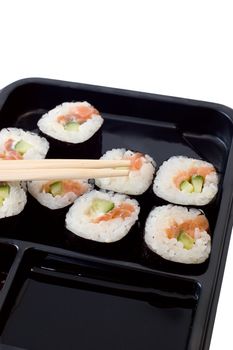 Rolls of sushi on a plate with chopsticks.