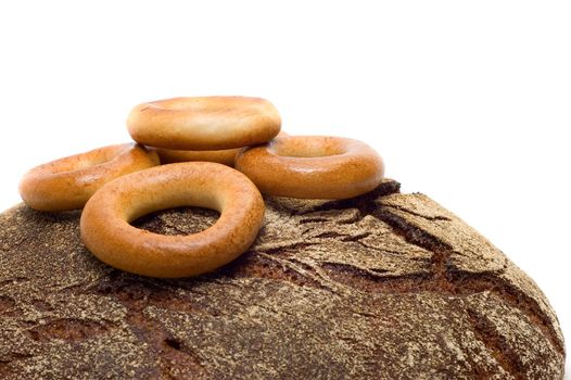 Loaf of bread and bread ring on white background