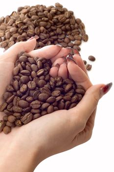 Female hands and coffee beans on white