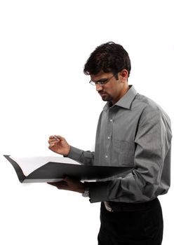 An Indian business executive signing documents in a file, on white studio background.