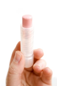 female hand holding pink lipstick