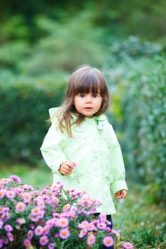 Clouse-up portrait pretty little girl in the park with a flower