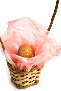 decorated orange easter egg in wooden handmade basket