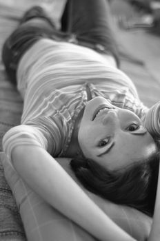 Portrait of happy young woman resting on floor at home