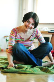Portrait of happy young woman resting on floor at home
