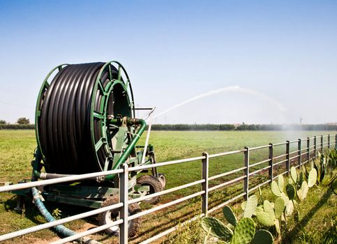 Irrigation operations in Italian country during a sunny day