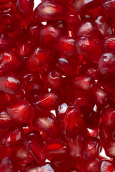 Macro up view of peeled red ripe pomegranate seeds.
