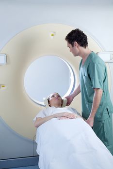 A CT scan machine with patient and nurse