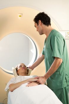 A nurse assisting a patient in a CT scanner giving comfort