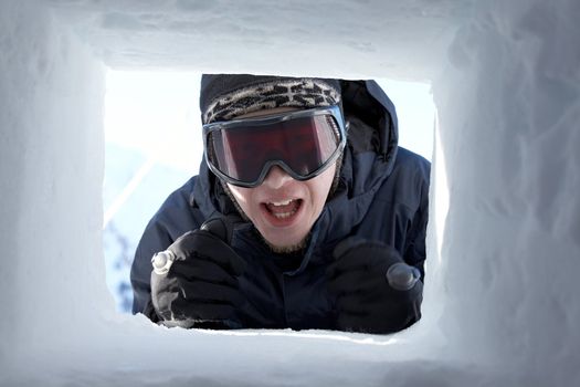 Skier in the window of a hut made of snow