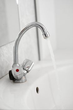 water flowing from the tap in the bathroom