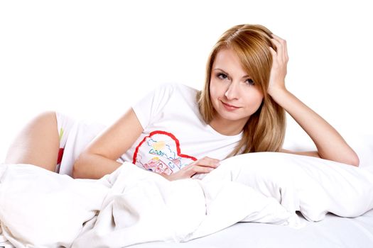 woman lying in bedroom smiling on a white background