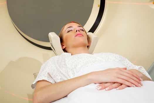 A young woman undergoing a CT scan in a hospital