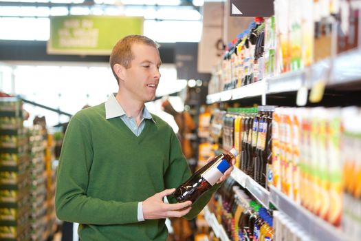 Customer buying bottle of juice in the supermarket