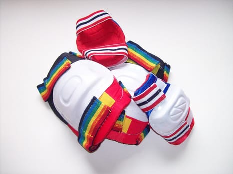 Elbow and knee pads in a pile over a white surface