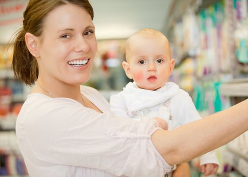 A happy baby and mother in a grocery store buying groceries