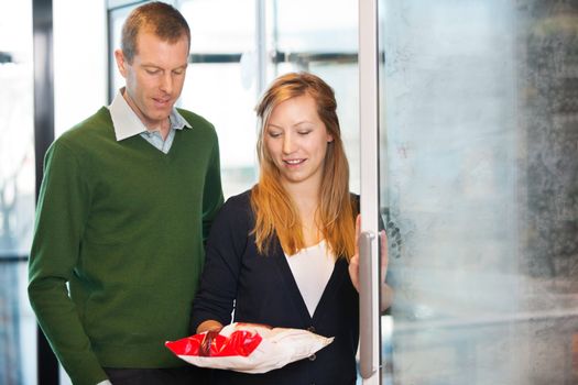 Woman taking out product from freezer while shopping with husband