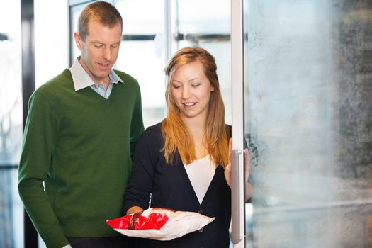 Woman taking out product from freezer while shopping with husband