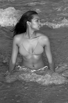 Ethnic bikini model posing in the shallow water
