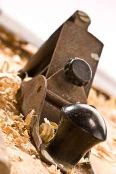 Old plane on wooden table with shavings