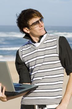 Young male professional working at the beach 